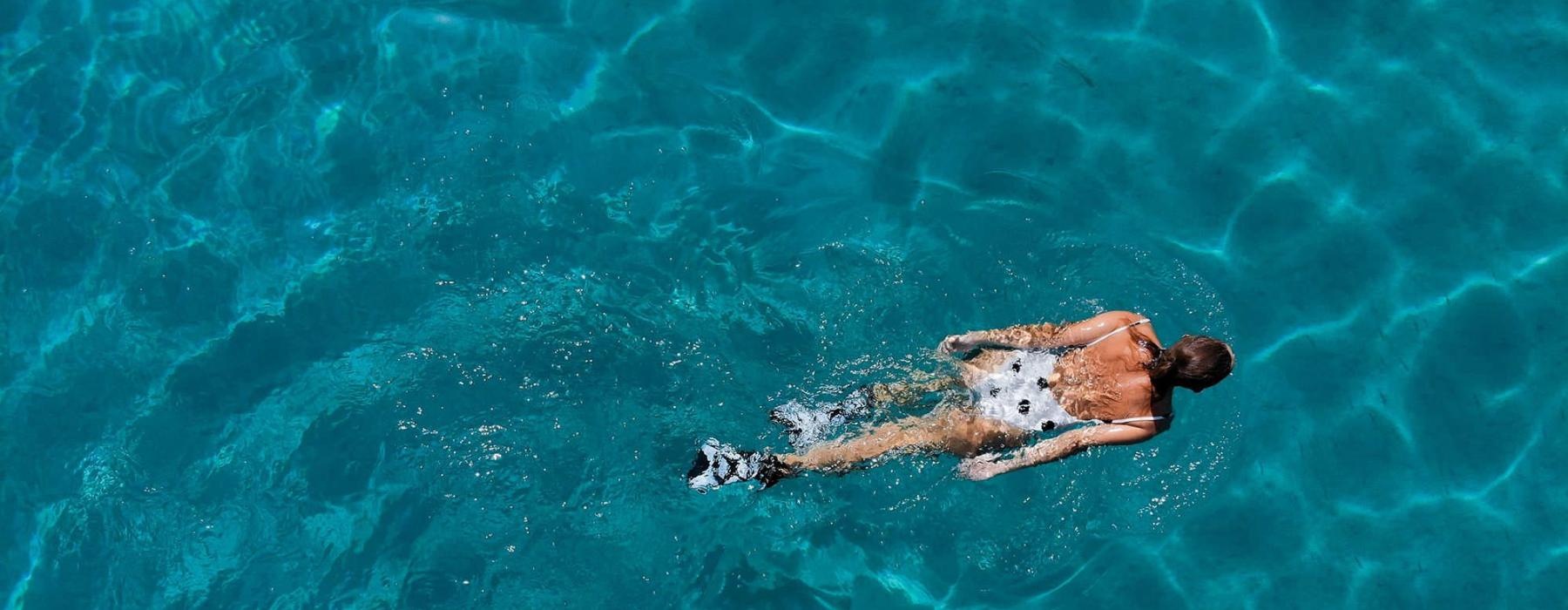 overhead shot of a woman swimming in a pool